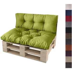 Mała drewniana sofa z palet z grubą, pikowaną zieloną poduszką. Po prawej stronie znajdują się próbki różnych kolorów tkanin, w tym niebieskiego, czerwonego, szarego, brązowego i beżowego.